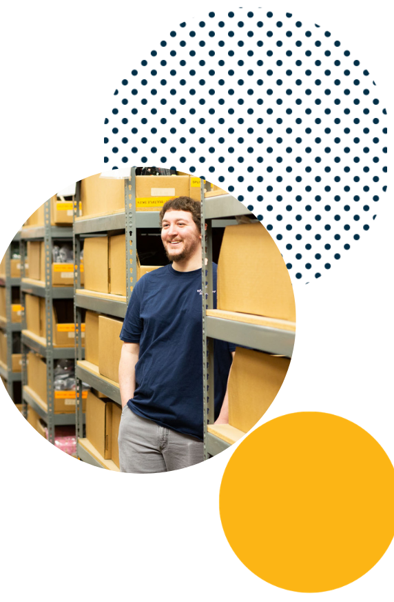 Efulfillment Service Employee Young Male Smiling From Between Racks