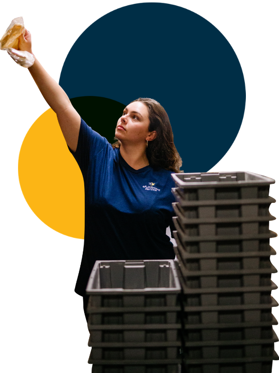 eFulfillment Service Employee With Stacked Bins Reaching Left